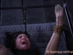 A strapped-down beauty is forced to fuck a thick dildo while whipped