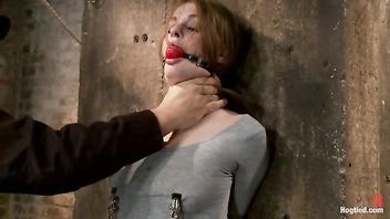 A fiery redhead gets her puffy nipples clamped in tight bondage